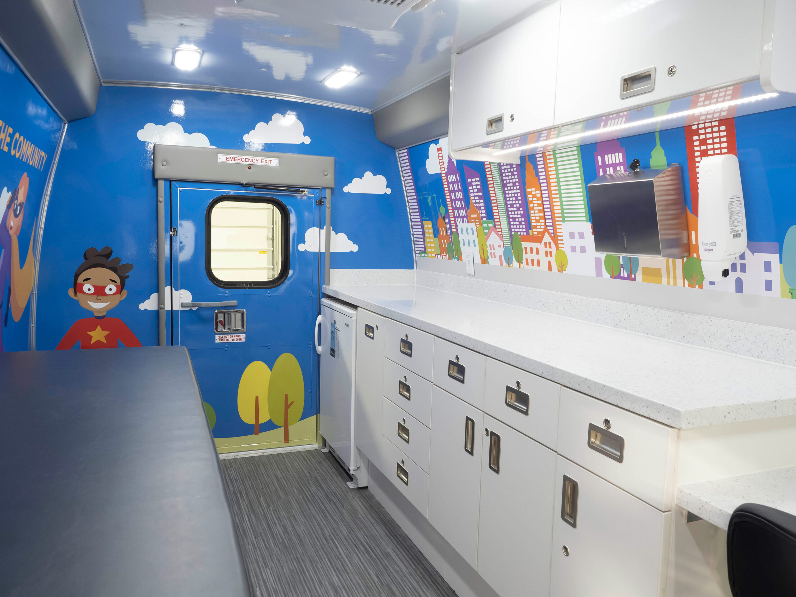 Image of the inside of a mobile pediatrics clinic with superhero decals on the walls.