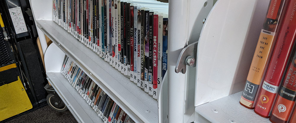 DVDs lined up on a shelf.