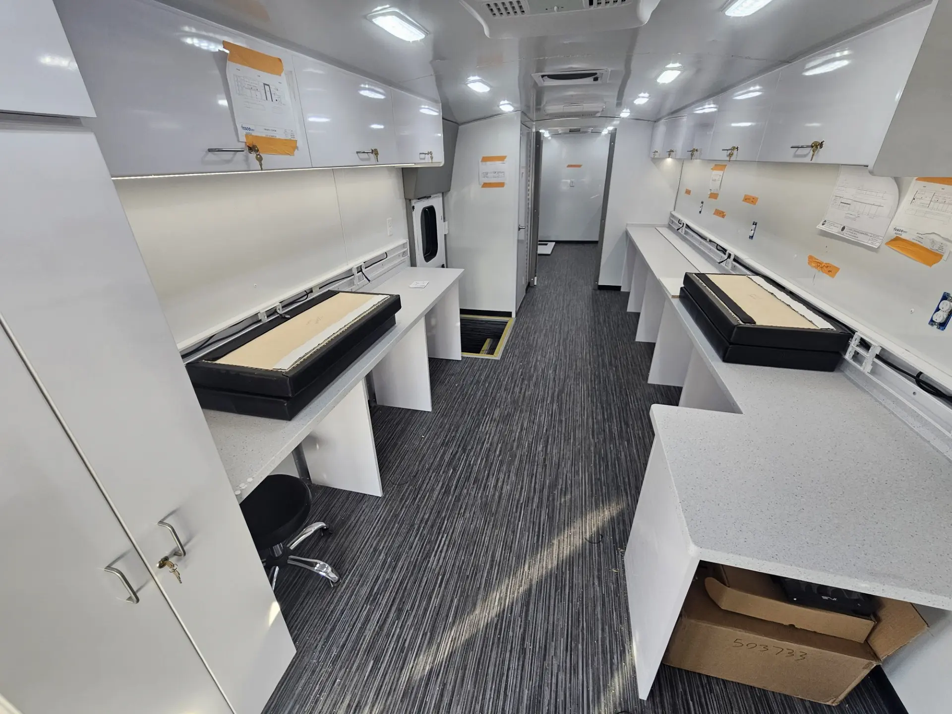 Interior of the City of Norfolk Mobile Workforce Center showing dual workstation desks and overhead cabinets